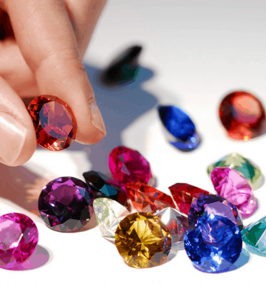Number of different coloured gemstones lying on the surface.